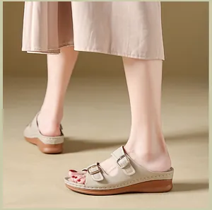 Detail shot of stylish beige wedge sandals featuring double buckles and platform soles