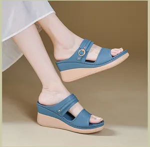 Detailed close-up of blue wedge sandals with decorative buckle and stitching for women.