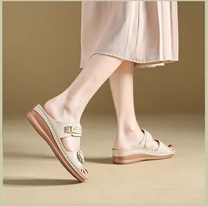 Detail view of women's beige wedge sandals featuring elegant flower decor and stitching
