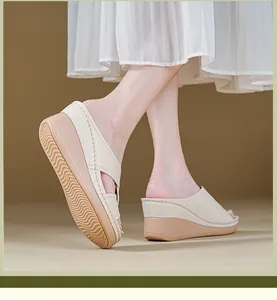 Close-up of stylish beige platform wedge sandals featuring decorative white stitching