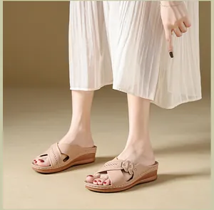 Close-up view of elegant wedge sandals for women with decorative perforated straps.