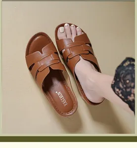 Close-up of brown leather H-strap sandals showing detailed stitching and insole brand.