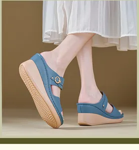 Close-up detail of women's blue wedge sandals featuring elegant stitching and a metal buckle decoration