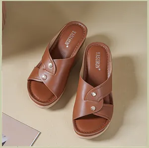 Detailed top-down view of brown leather wedge sandals with decorative silver studs.