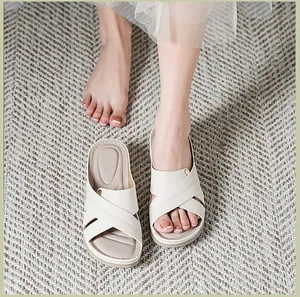 Vue détaillée de sandales compensées beige avec brides croisées et surpiqûres décoratives.
