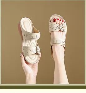 Detailed view of beige wedge sandals featuring floral accents and laser-cut retro design.