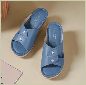 Top view of blue wedge sandals with cross-strap design and metal studs