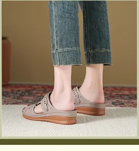 Close-up of stylish wedge sandals with floral hollow-out pattern worn by a model