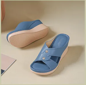 Detailed close-up of blue women's wedge sandals with cross straps and metallic buttons