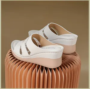 Detailed view of women's wedge sandals with cross-strap design in beige