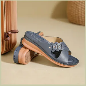 Macro detail of navy blue women's wedge sandals with decorative metal studs and non-slip sole