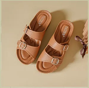Detailed view of women's brown wedge sandals featuring double adjustable metal buckles