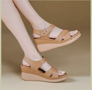 Side view of comfortable brown wedge sandals with stylish metallic studs and thick sole
