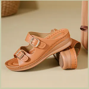 Detailed side view of stylish tan wedge sandals with adjustable double metal buckles