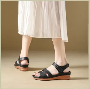Detailed view of women's black strappy wedge sandals with comfortable magic tape closure