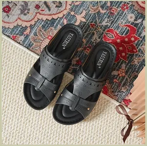 Detail view of black wedge sandals featuring elegant laser-cut floral patterns and soft insole.