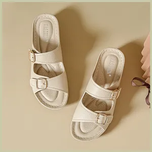 Top view detail of stylish breathable beige wedge sandals with double gold buckles