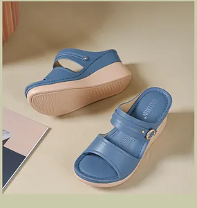 Close-up detail of stylish blue wedge sandals featuring breathable perforated footbed and buckle