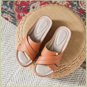 Vue de dessus de sandales compensées brunes pour femmes avec brides croisées sur un pouf