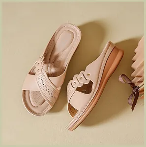 Detailed view of beige wedge sandals with elegant perforated patterns and gold studs.
