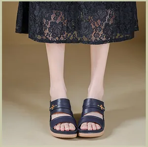 Close-up of navy blue wedge sandals with gold stud details and double straps