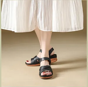 Detailed close-up view of black wedge sandals with crisscross straps and velcro