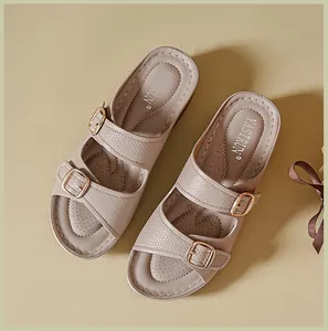 Detailed top view of beige wedge sandals with decorative buckles and breathable insoles.