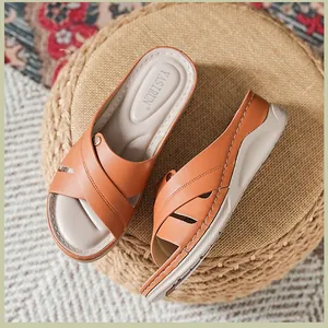 Vue détaillée des sandales compensées orange pour femmes avec coutures croisées.