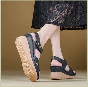 Close-up of black wedge sandals featuring tan non-slip sole and metal buckle detail.