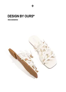 Close-up of fashionable white square toe slippers with an elegant leaf cutout design