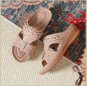 Detail view of beige wedge sandals with laser-cut patterns and peep-toe design