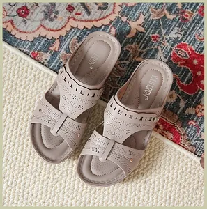 Top view detail of beige women's wedge sandals with decorative laser-cut patterns