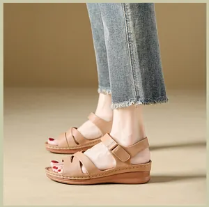 Detail view of khaki wedge sandals with adjustable hook-and-loop straps on model