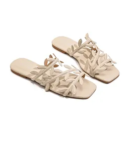 Elegant cream-colored square-toe flat slides for women featuring unique vine-shaped straps.