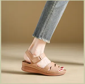 Close-up detail of women's brown wedge sandals with velcro strap and stitched sole design