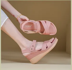 Close-up of pink wedge sandals with metal buckle and comfortable cross straps