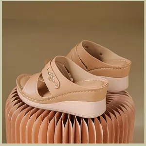 Detailed side view of stylish apricot wedge sandals with decorative stitching