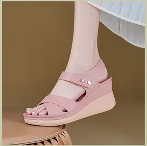 Detailed side view of pink platform sandals with metal buckles shown on a model's foot
