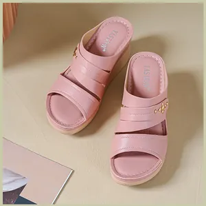 Detailed view of pink women's wedge sandals with triple straps and metallic studs decoration