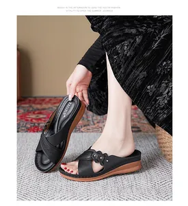 Detail of black wedge slides for women featuring flower accents and cross straps.