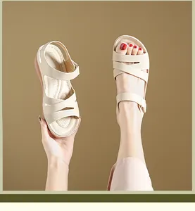 Close-up of beige wedge sandals with textured cross-straps and secure velcro closure