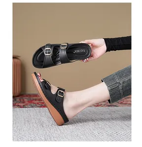 Detail view of black wedge sandals with dual metal buckles and breathable open toe design.