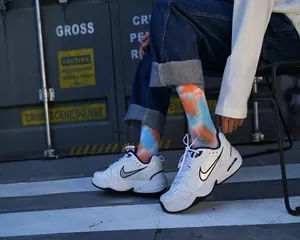 Vista dettagliata di calzini tie-dye blu e arancioni abbinati a scarpe da ginnastica