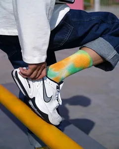Vista dettagliata di vivaci calze tie-dye con motivi gialli e verdi indossate da un modello