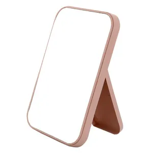 Large pink folding desktop makeup mirror with adjustable stand shown from a side angle