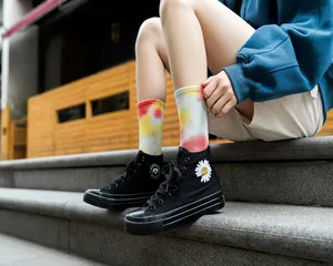 Calze tie-dye colorate in stile streetwear indossate con scarpe da ginnastica nere