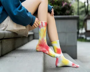 Vista dettagliata di vivaci calze tie-dye multicolore indossate all'aperto su scalini di pietra