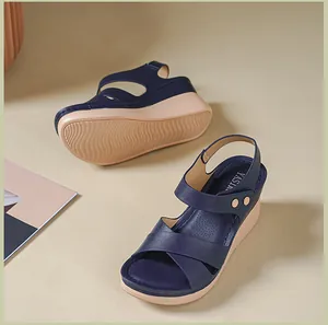 Close-up of navy blue wedge sandals with metal buckle and textured leather straps