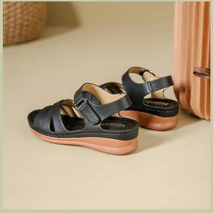 Detailed side view of black women's wedge sandals featuring adjustable Velcro straps