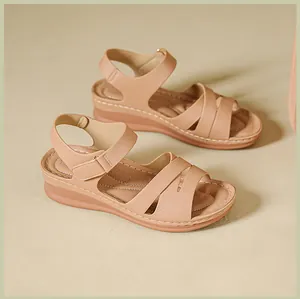 Close-up detail view of beige platform wedge sandals with adjustable hook and loop straps